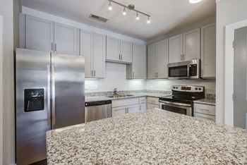 a kitchen with a large island and stainless steel appliances